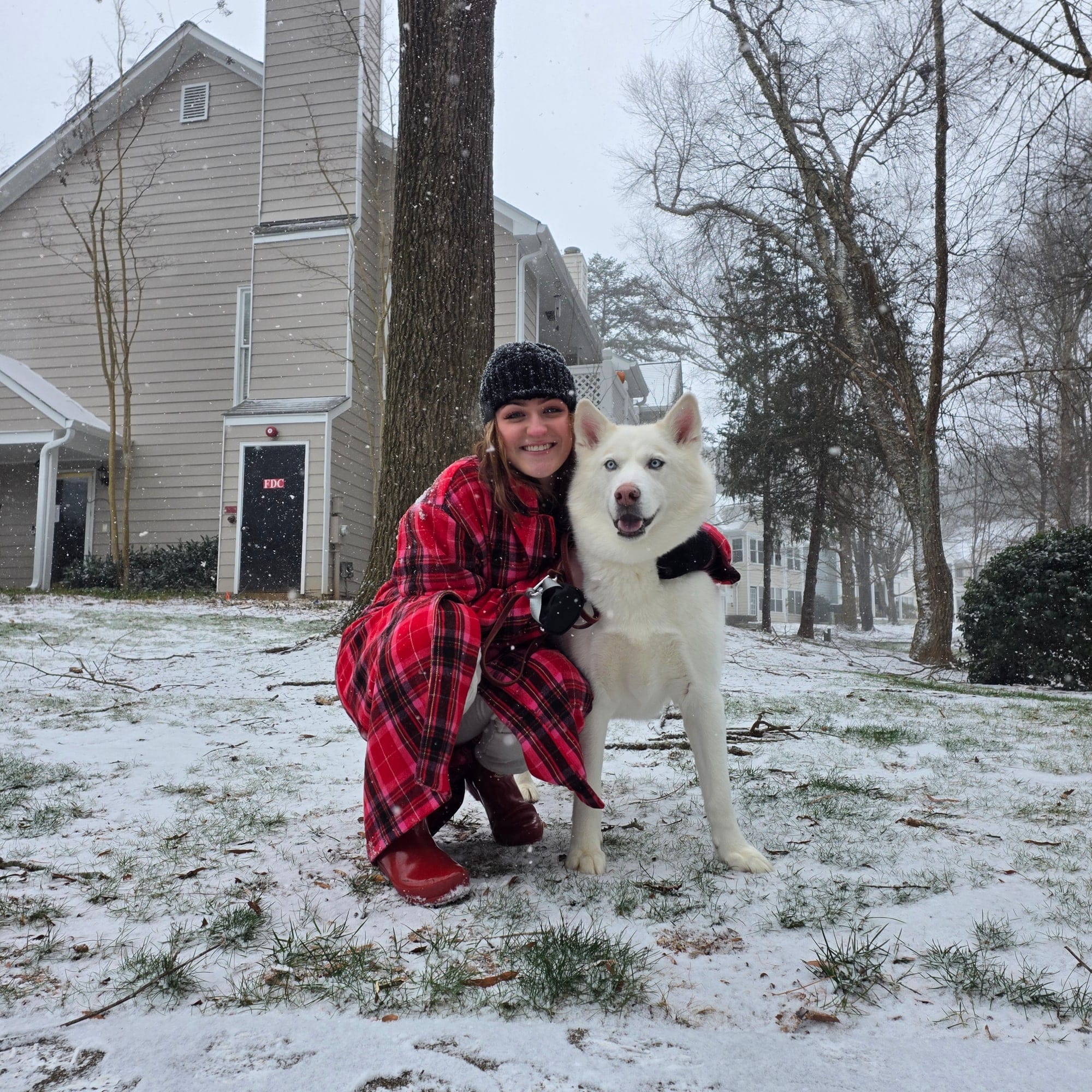 Lili Barker outside in the snow with her white husky